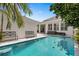 Backyard pool surrounded by paved patio, greenery, and a white house with large windows, perfect for outdoor enjoyment at 10003 Brompton Dr, Tampa, FL 33626