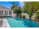 Outdoor pool with a clean, blue surface, surrounded by a paved patio and lush landscaping, next to an outdoor seating area at 10003 Brompton Dr, Tampa, FL 33626