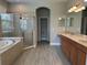Bathroom featuring tub, glass shower, double vanity, with granite countertop at 1008 Arista Blvd, Valrico, FL 33594