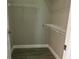 Small walk-in closet with white wire shelving and gray wood-look tile floor at 1008 Arista Blvd, Valrico, FL 33594