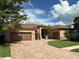 Beautiful home boasts a three car garage, a brick driveway, and stone accents at 1008 Arista Blvd, Valrico, FL 33594
