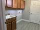 Well-lit laundry room features upper and lower cabinets, a sink and tile flooring at 1008 Arista Blvd, Valrico, FL 33594