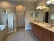 Bathroom featuring double sinks, granite countertops, tiled floors, and a glass-enclosed shower at 1008 Arista Blvd, Valrico, FL 33594