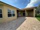 A spacious brick patio leads to the home's sliding glass doors and a serene outdoor view at 1008 Arista Blvd, Valrico, FL 33594