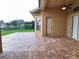 Covered outdoor patio features brick pavers, a ceiling fan, and views of the yard at 1008 Arista Blvd, Valrico, FL 33594
