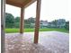 Covered patio with brick pavers overlooks the lush backyard and lake at 1008 Arista Blvd, Valrico, FL 33594