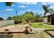 Backyard with wooden deck, lush greenery, garden beds, and ample space for gardening and outdoor activities at 10549 112Th Ave, Largo, FL 33773