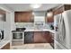 Kitchen features dark wood cabinets, marble countertops, tile backsplash, and stainless appliances at 10549 112Th Ave, Largo, FL 33773