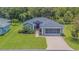 Charming single-story home with well-manicured lawn, brick driveway, and a screened-in two car garage at 10728 Moshie Ln, San Antonio, FL 33576