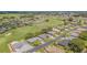 Beautiful aerial view of a well-maintained community near a golf course and a tranquil lake at 10728 Moshie Ln, San Antonio, FL 33576