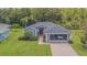 Charming single-story home with well-manicured lawn, brick driveway, and a screened-in two car garage at 10728 Moshie Ln, San Antonio, FL 33576