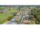 Aerial view of neighborhood with well-kept homes bordering a golf course and a scenic pond at 10728 Moshie Ln, San Antonio, FL 33576