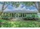Inviting backyard featuring a sunroom, well-maintained lawn, and lush landscaping for ultimate relaxation at 10728 Moshie Ln, San Antonio, FL 33576