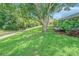 Well-manicured lawn in backyard, features mature trees and landscaping alongside home's exterior at 10728 Moshie Ln, San Antonio, FL 33576