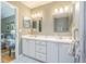 Bathroom featuring double vanity with white cabinets and square mirrors at 10728 Moshie Ln, San Antonio, FL 33576