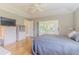 Bright bedroom with neutral walls, wood floors, tray ceiling, and sliding glass doors to lanai at 10728 Moshie Ln, San Antonio, FL 33576