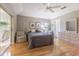 Light-filled bedroom features a tray ceiling, wood floors, and adjacent sitting area at 10728 Moshie Ln, San Antonio, FL 33576