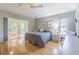 Light filled bedroom with hardwood floors, neutral paint, a ceiling fan, and access to the lanai at 10728 Moshie Ln, San Antonio, FL 33576