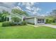 Charming single-story home with well-manicured lawn, brick driveway, and a screened-in two car garage at 10728 Moshie Ln, San Antonio, FL 33576