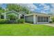 Charming home with well-kept lawn, manicured bushes, and a brick pathway leading to front door at 10728 Moshie Ln, San Antonio, FL 33576