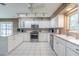 Spacious kitchen featuring white cabinets, stainless appliances, and tile floors at 10728 Moshie Ln, San Antonio, FL 33576