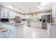 Bright, well-lit kitchen with white cabinets, stainless steel appliances, and tile floors at 10728 Moshie Ln, San Antonio, FL 33576