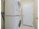 Convenient laundry room featuring a stacked washer and dryer, plus access to a utility closet at 10728 Moshie Ln, San Antonio, FL 33576