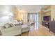 Bright living room featuring hardwood floors, neutral paint, a ceiling fan, and comfortable furniture at 10728 Moshie Ln, San Antonio, FL 33576