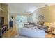 Bright living room featuring hardwood floors, neutral paint, a ceiling fan, and comfortable furniture at 10728 Moshie Ln, San Antonio, FL 33576