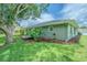 Well maintained yard with mature trees, lush grass and plantings and the rear exterior of the home at 10728 Moshie Ln, San Antonio, FL 33576