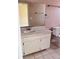 Functional bathroom with a single sink vanity, a large mirror, and tile flooring, providing essential amenities at 11022 Connacht Way, Tampa, FL 33610