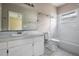 Well-lit bathroom with a white vanity, large mirror, and a combination tub and shower at 11022 Connacht Way, Tampa, FL 33610