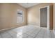 Clean bedroom boasts tile flooring, natural light, and a closet at 11022 Connacht Way, Tampa, FL 33610