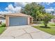 Front view of the house with a two-car garage, driveway, and well-maintained lawn at 11022 Connacht Way, Tampa, FL 33610