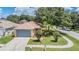 Charming single-story home with a well-maintained lawn, palm trees, and attached two-car garage at 11022 Connacht Way, Tampa, FL 33610