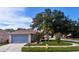 A home with a two-car garage and well-maintained lawn with mature landscaping at 11022 Connacht Way, Tampa, FL 33610