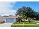 A home with a two-car garage and well-maintained lawn with mature landscaping at 11022 Connacht Way, Tampa, FL 33610