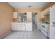 Functional kitchen layout with white appliances, ample cabinet space, and durable tile flooring at 11022 Connacht Way, Tampa, FL 33610