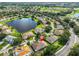 An aerial view of a suburban neighborhood featuring mature trees, a serene lake, and well-maintained landscaping at 1112 Mcdaniel St # 78, Sun City Center, FL 33573
