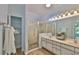 Bright bathroom featuring double sinks, glass shower and walk-in storage space at 1112 Mcdaniel St # 78, Sun City Center, FL 33573