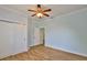Bright bedroom featuring wood-look floors, a closet, and doorway to another room at 1112 Mcdaniel St # 78, Sun City Center, FL 33573