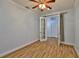 Bedroom featuring wood-look flooring, a ceiling fan and closet accessibility through french doors at 1112 Mcdaniel St # 78, Sun City Center, FL 33573