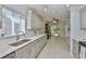 Bright kitchen featuring ample counter space, stylish cabinetry, stainless steel sink, and a large window at 1112 Mcdaniel St # 78, Sun City Center, FL 33573