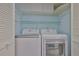 A well-organized laundry area featuring a modern washer and dryer and shelf for extra storage at 1112 Mcdaniel St # 78, Sun City Center, FL 33573