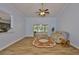 A cozy living room featuring wood-look tile, access to a screened lanai, and neutral decor at 1112 Mcdaniel St # 78, Sun City Center, FL 33573