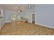 Bright living room with vaulted ceilings, wood-look tile, and glass doors to a screened porch at 1112 Mcdaniel St # 78, Sun City Center, FL 33573