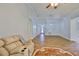 Spacious living room featuring wood-look tile flooring and a comfortable recliner with a round accent rug at 1112 Mcdaniel St # 78, Sun City Center, FL 33573