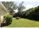 Spacious backyard with a lush lawn, mature trees, and a covered seating area, ideal for entertaining at 13637 13Th St, Dade City, FL 33525