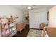Bedroom featuring hardwood floors, changing table, shelves for storage, and a closet at 13637 13Th St, Dade City, FL 33525