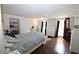 Bright bedroom with hardwood floors, white furniture, a ceiling fan, and access to a private balcony at 13637 13Th St, Dade City, FL 33525